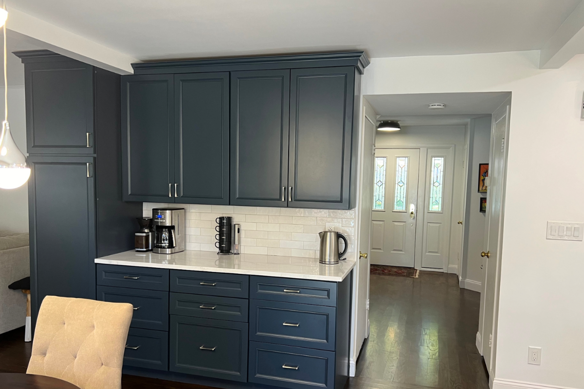 L-shaped decorative white kitchen design with indigo blue island and white quartz countertops