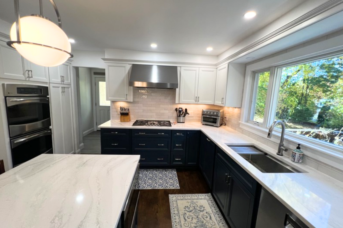 L-shaped decorative white kitchen design with indigo blue island and white quartz countertops