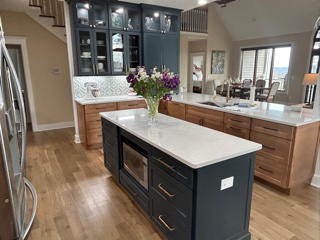 Light wood kitchen cabinets with indigo furniture-style accents and white quartz countertops