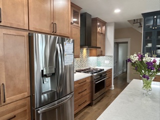 Light wood kitchen cabinets with indigo furniture-style accents and white quartz countertops