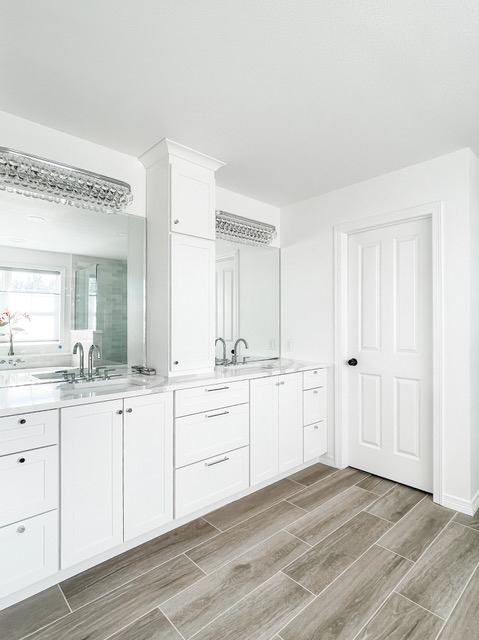 White shaker bathroom vanity cabinets with a stacked wall cabinet tower in the center