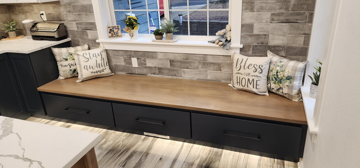 Custom blue shaker cabinet bench seat with light wood top in farmhouse style