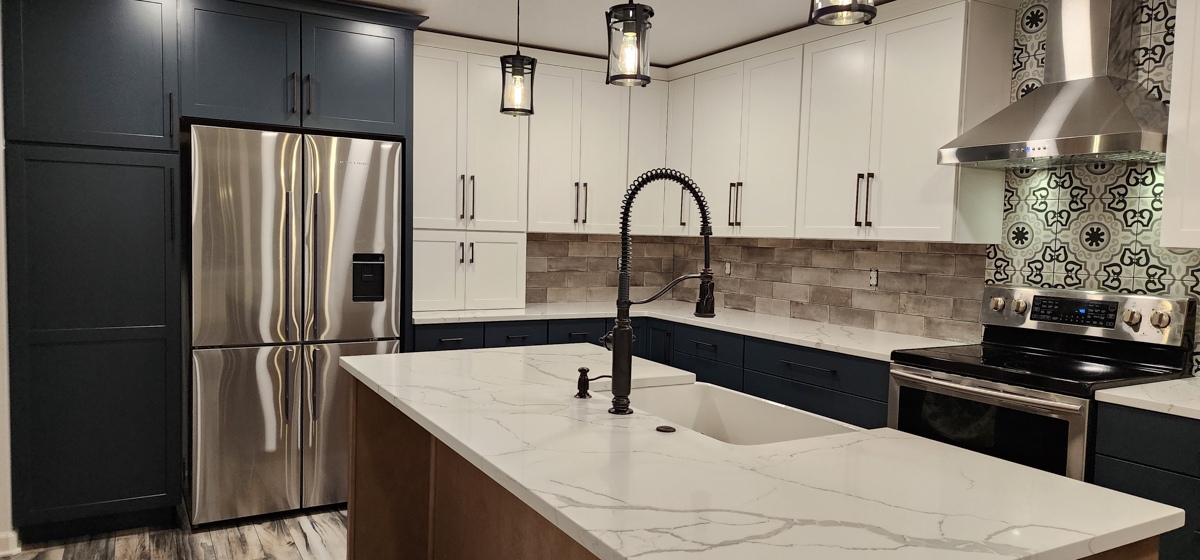 Farmhouse kitchen with white shaker wall cabinets, blue shaker base cabinets, and light wood furniture-style island