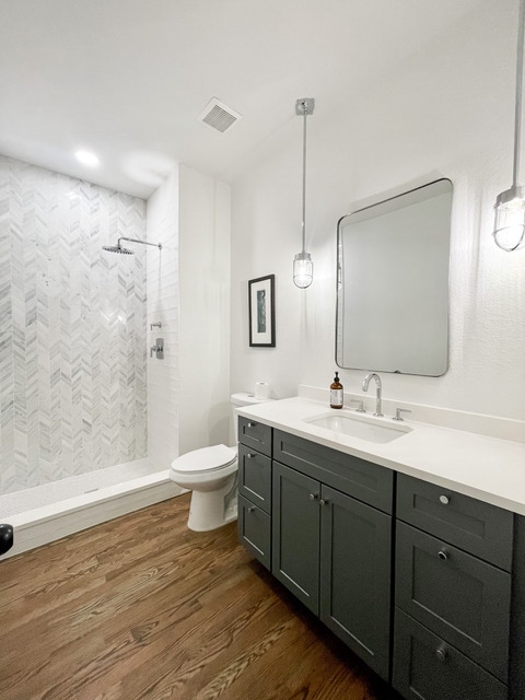 Dark gray shaker bathroom vanity cabinets with drawers and a white quartz countertop