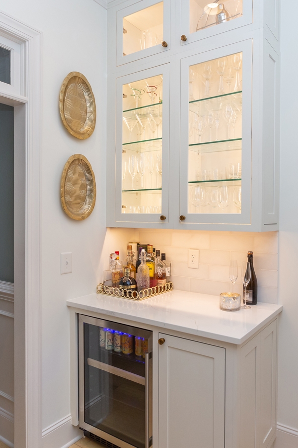 White cabinet Butlerâs pantry with wine refrigerator and glass door fronts