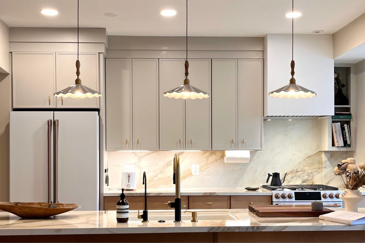 Thin shaker kitchen cabinets with creme upper cabinets and medium wood-tone base cabinets