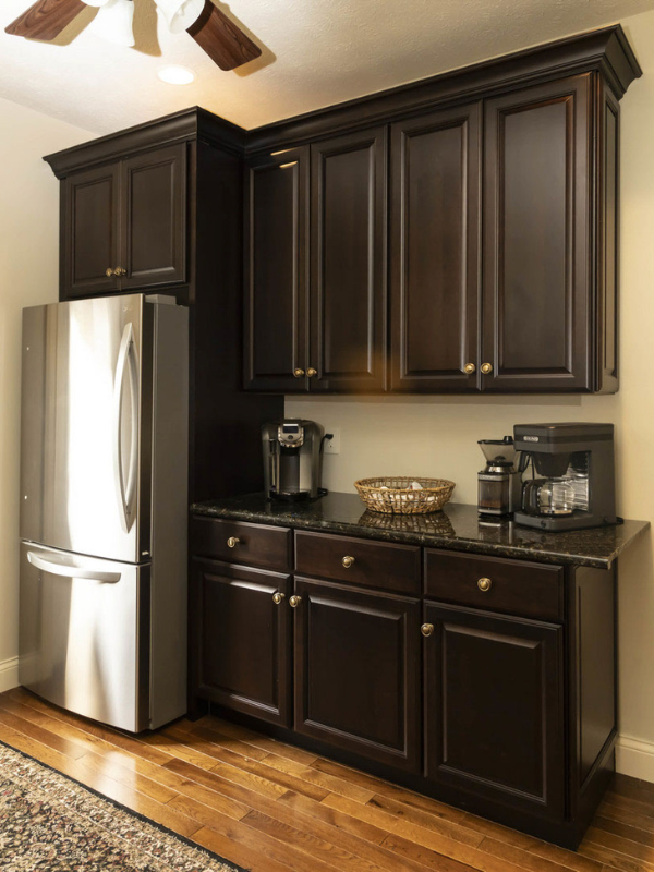 Traditional dark cherry refrigerator surround with kitchen cabinets and crown molding