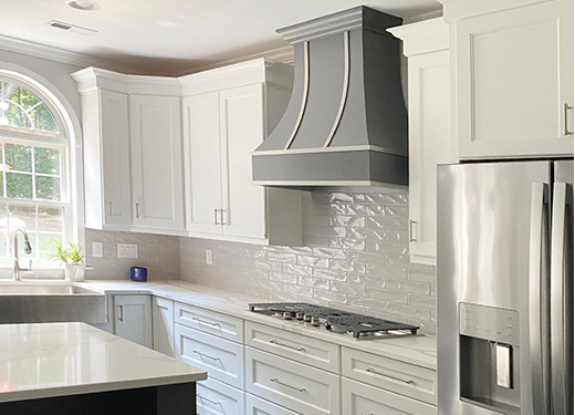 Curved wood kitchen hood in gray finish with steel strapping