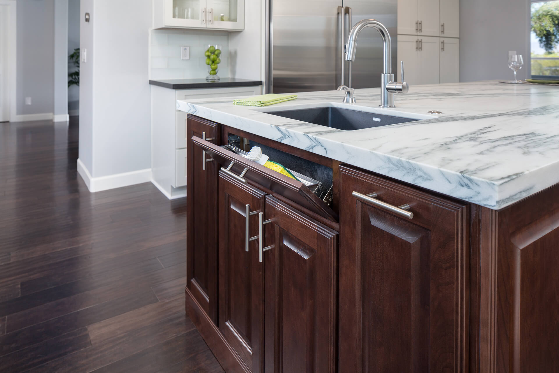 This image is of brown sink base pull-out storage cabinet that is essentially used to store kitchen cleaning materials.