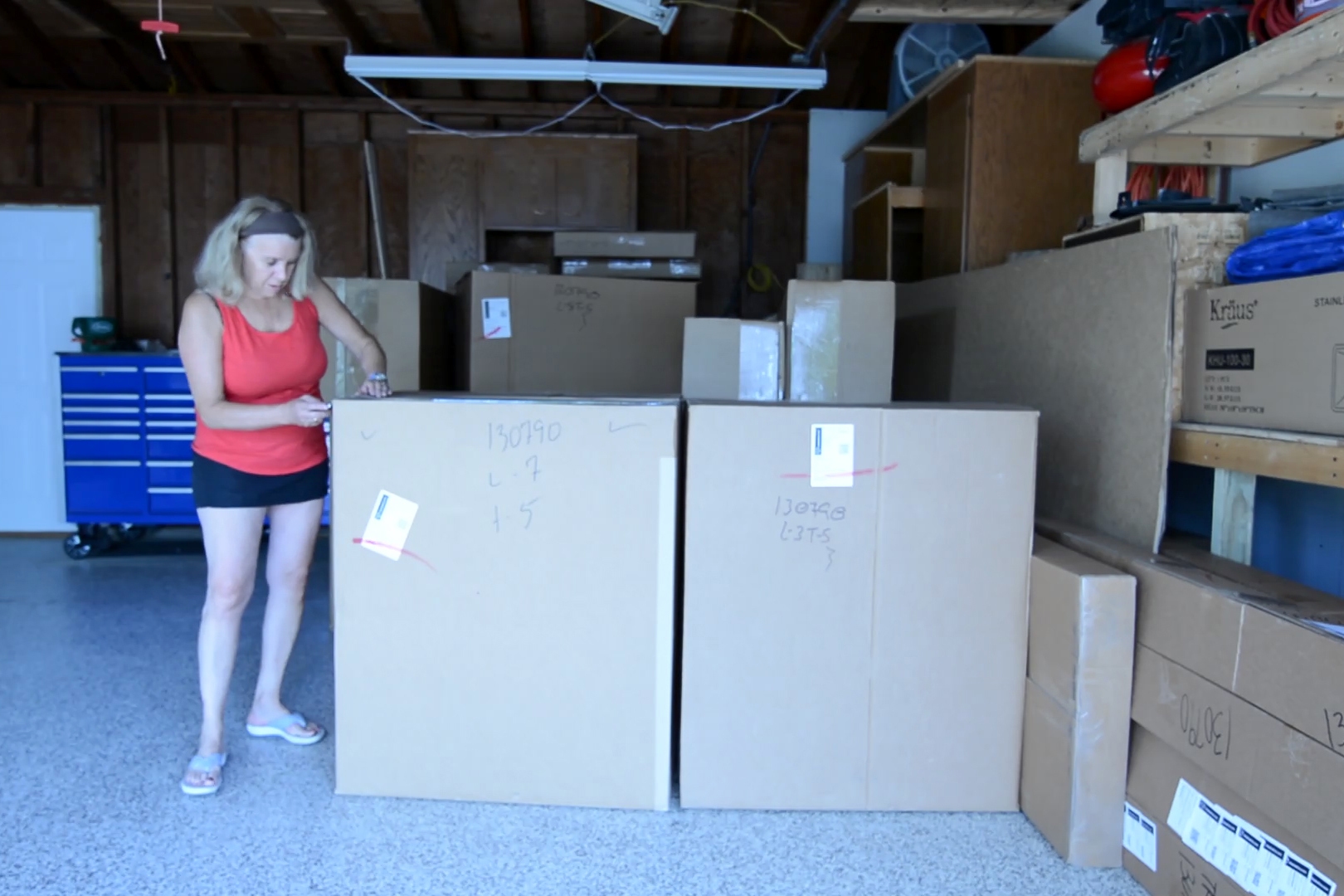 Homeowner with blonde hair in a red shirt inspecting entire cabinet order