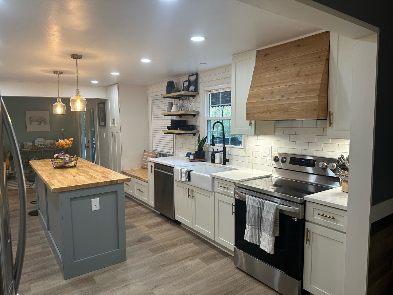 CliqStudios project: White shaker cabinets with a pine wood hood and light gray shaker island cabinets