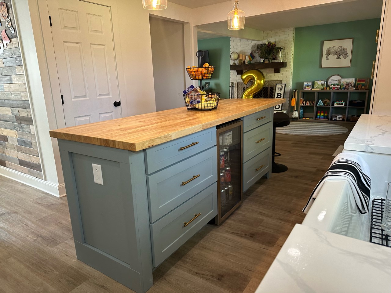 CliqStudios project: Light gray shaker kitchen island drawer cabinets with a beverage cooler in the center and wood butcher block countertop