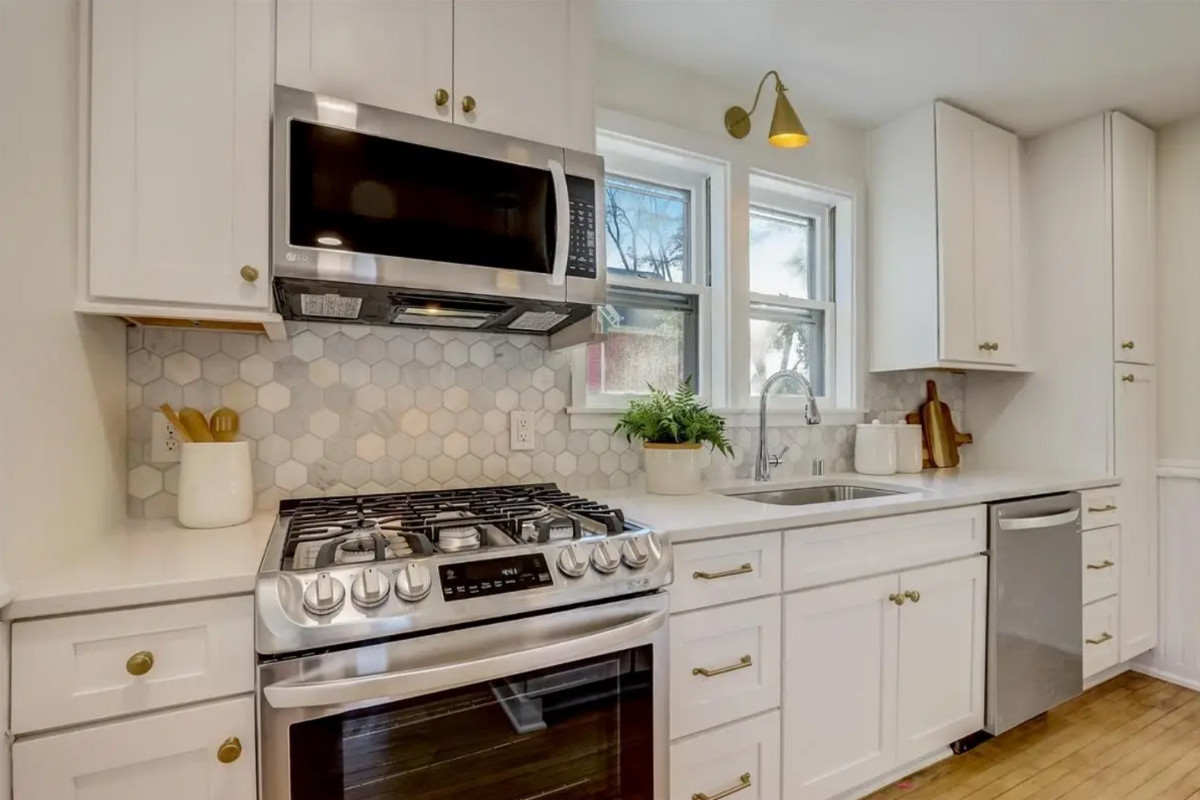 White shaker one-wall kitchen design with gold cabinet hardware and accents