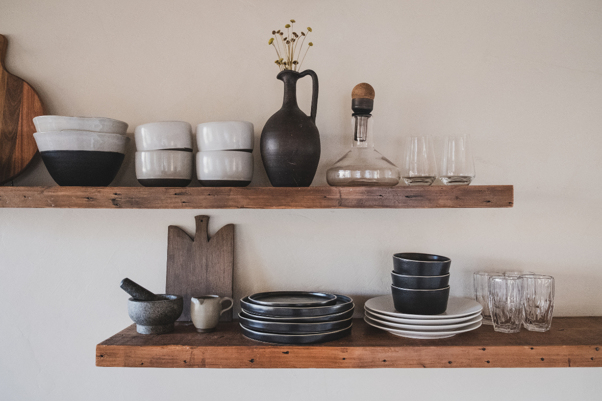 Decorative wood floating shelves holding stacked bowls and cups