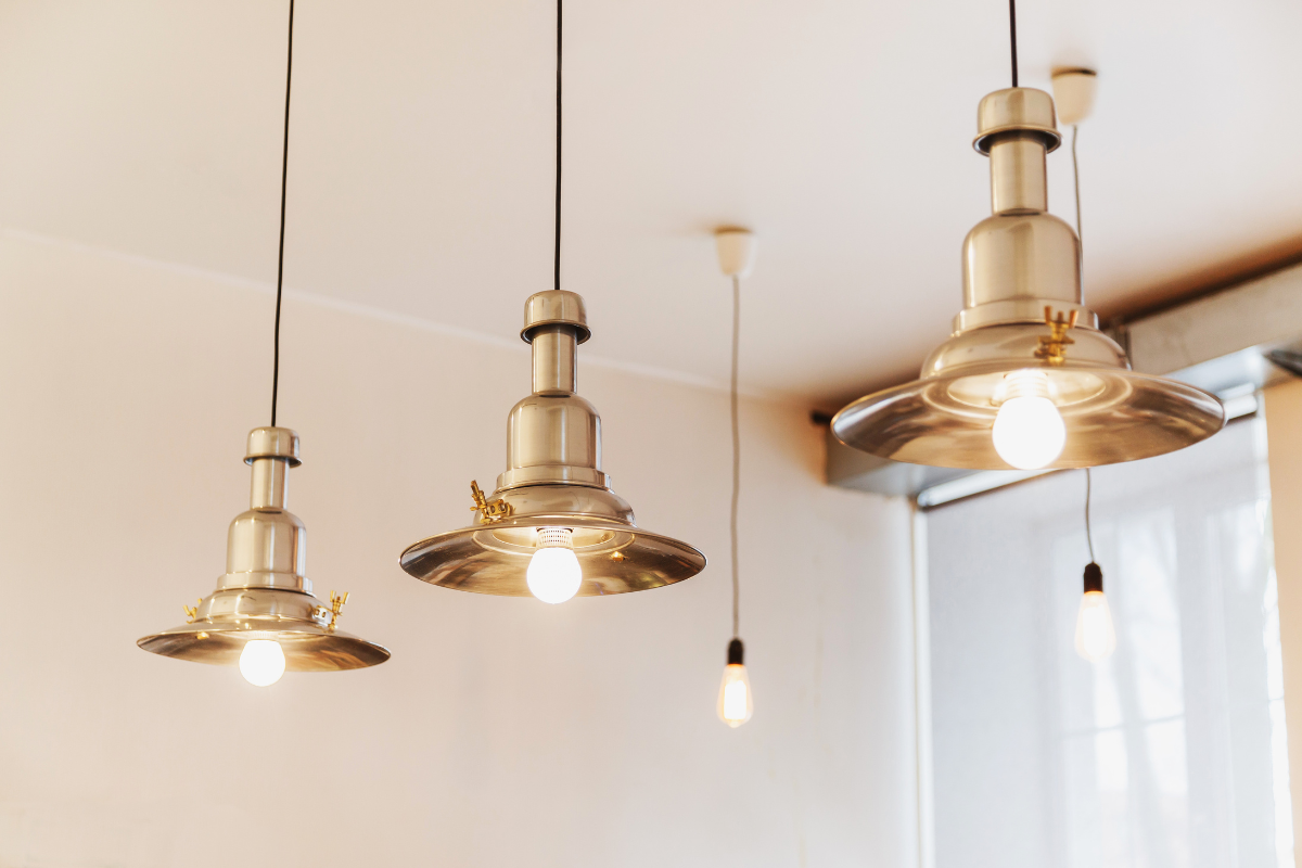 Three brass pendant lights hanging from the ceiling