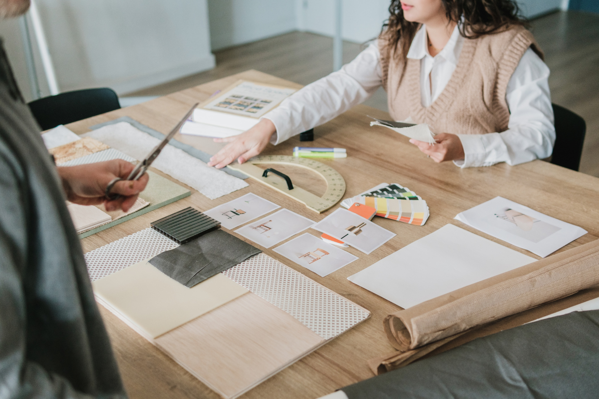 Interior designer comparing fabrics and finishes for a home remodel on a table