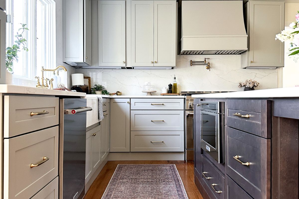 Light gray shaker kitchen with wood hood, white quartz countertops, and a large dark brown furniture-style island