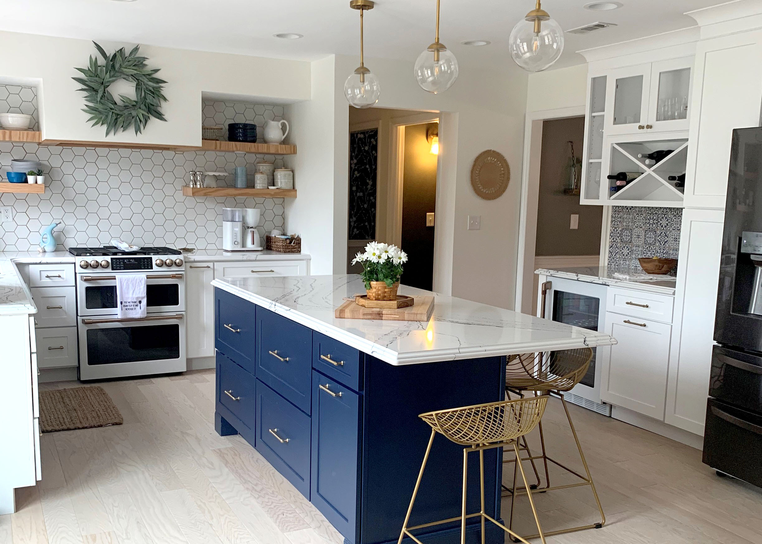 Farmhouse style white shaker kitchen cabinets and blue island with gold hardware