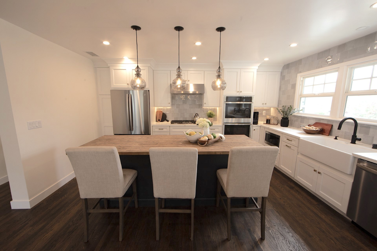Decorative white shaker kitchen cabinets with white quartz countertops, gold hardware, and an indigo blue island with butcher block countertops Decorative white shaker kitchen cabinets with white quartz countertops, gold hardware, and an indigo blue island with butcher block countertops