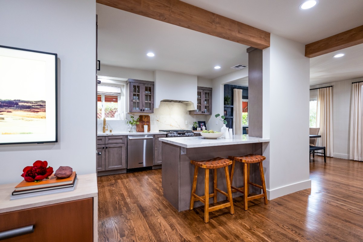 CliqStudios project: Light gray-brown stained kitchen cabinets with mullion doors, cream countertops, and a slab backsplash