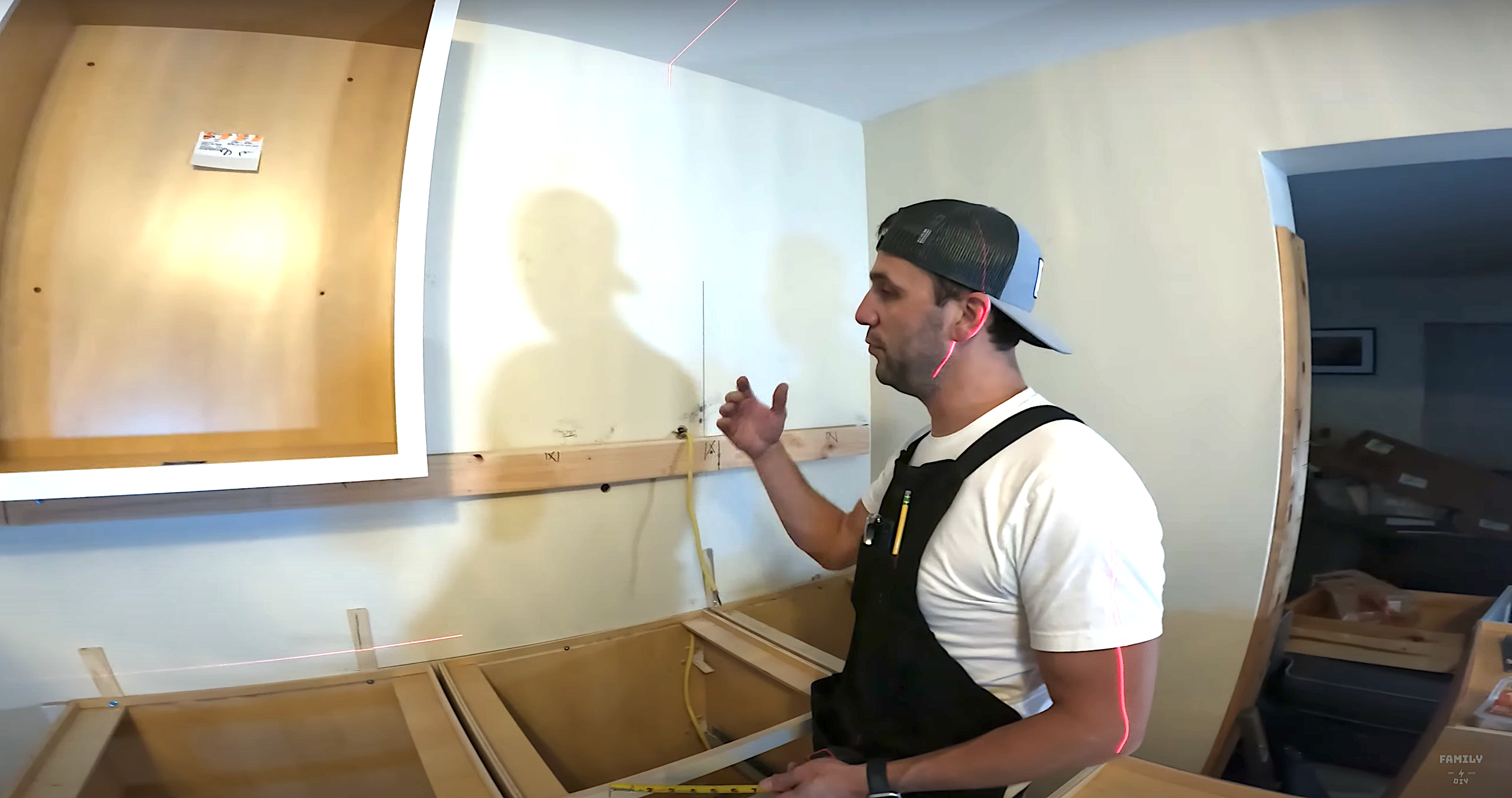 Mike Sante of Family DIY TV using a ledger rail to support wall cabinets during cabinet installation