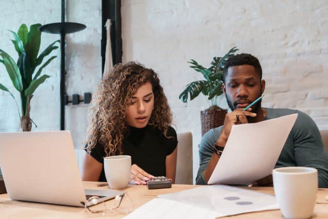 Couple with a computer looking over documents