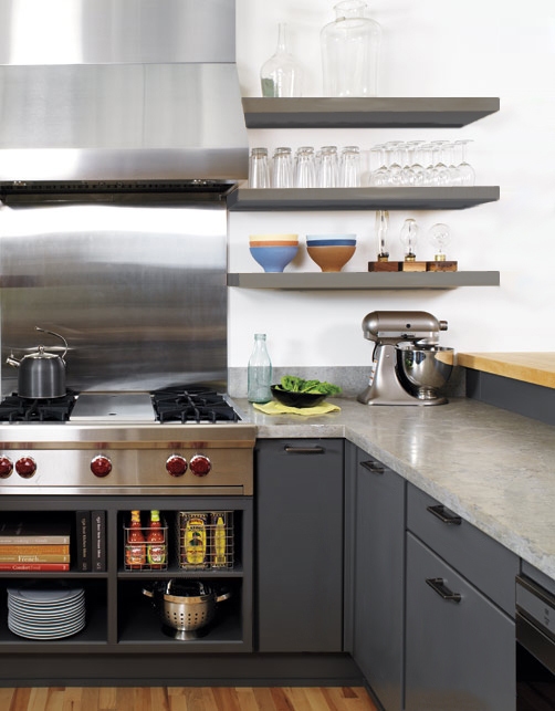 modern gray kitchen with slab door cabinets, floating shelves and stainless pro cooktop and range hood and backsplash