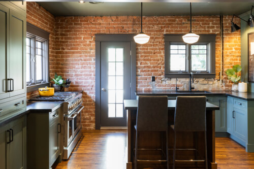 Medium tone wood kitchen cabinets in green with dark brown island