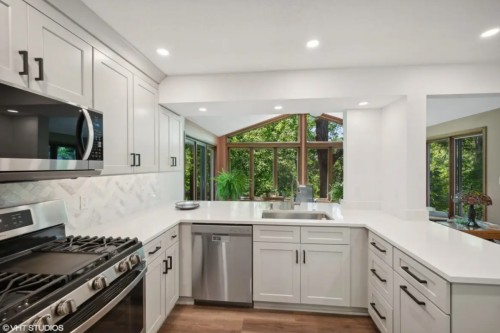 Light gray U-shaped peninsula kitchen design with white quartz countertops