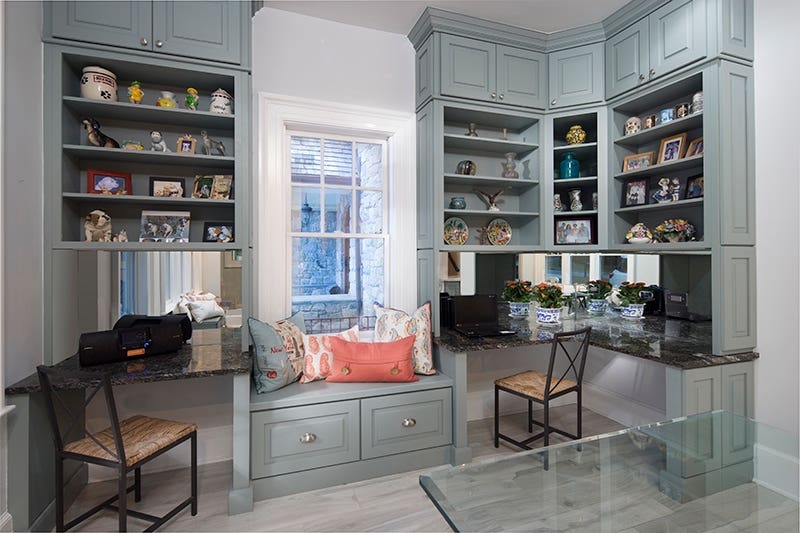 Decorative light gray office cabinetry with decorated open shelves and bench seat