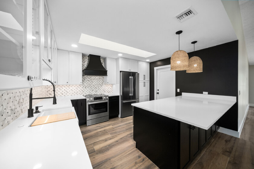 White and black shaker kitchen design with black wood hood and island with white quartz countertops