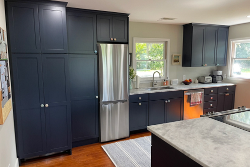 One-wall shaker kitchen design with navy blue cabinets and a matching island with light quartz countertops