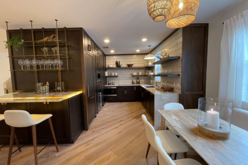 U-shaped upscale loft kitchen with dark brown kitchen cabinets, floating shelves throughout, modern white vertical tile backsplash for kitchen cabinets and waterfall quartz countertops