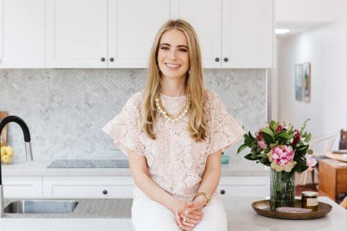 Interior designer in light pink lace shirt with blonde hair smiling