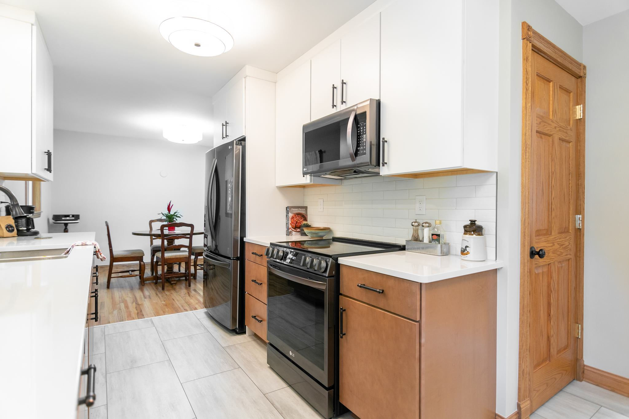 CliqStudios project: White and natural wood slab kitchen cabinets with white subway tile backsplash