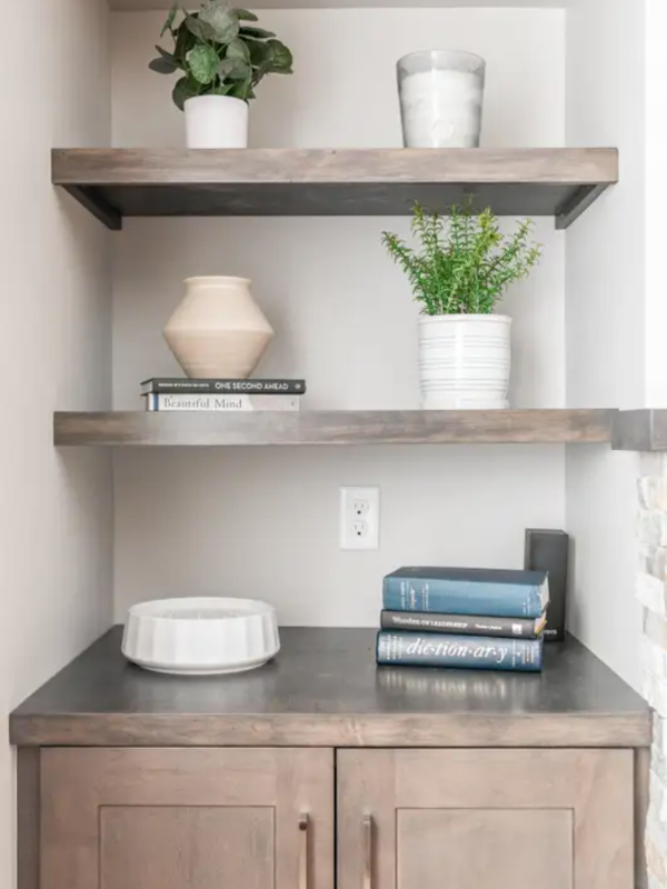 Medium-toned brown entertainment center base cabinet with floating shelves above