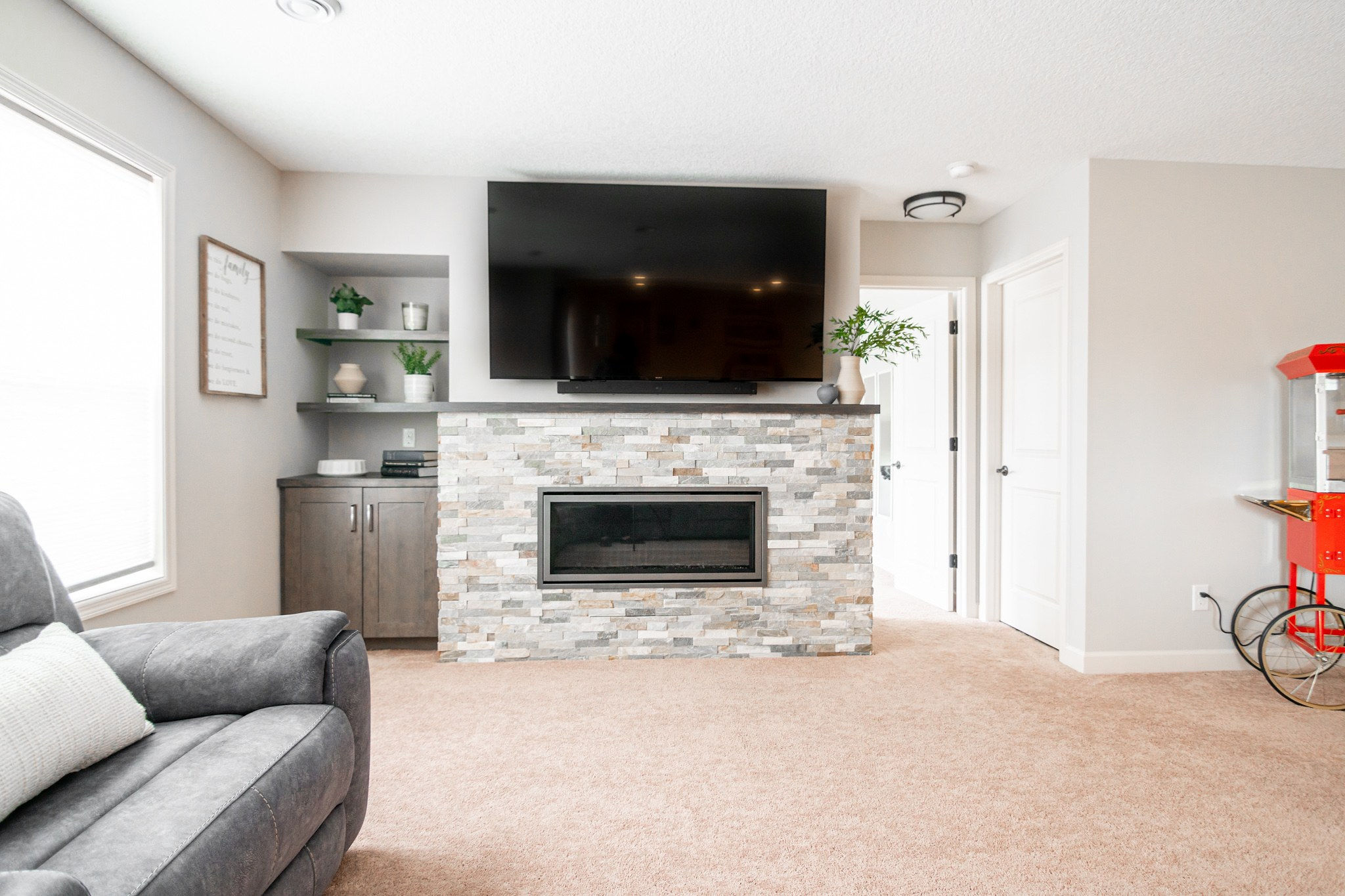 CliqStudios project: Warm wood shaker cabinets in small entertainment center with floating shelves