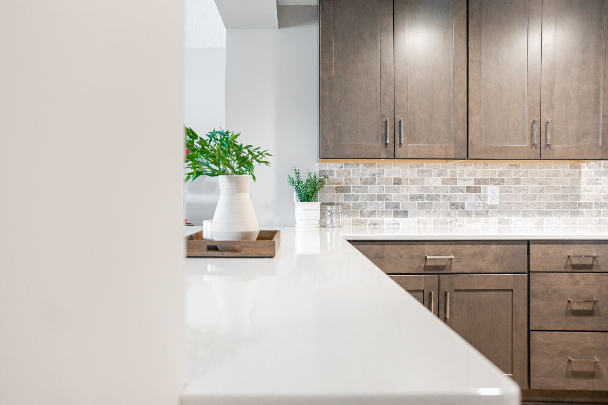 CliqStudios project: Warm wood shaker kitchen cabinets in a basement bar with tile backsplash