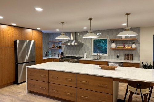 Medium cherry slab door kitchen cabinets with with built-in refrigerator and large center island