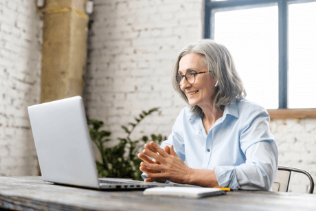 Older woman on a virtual conference with ear buds