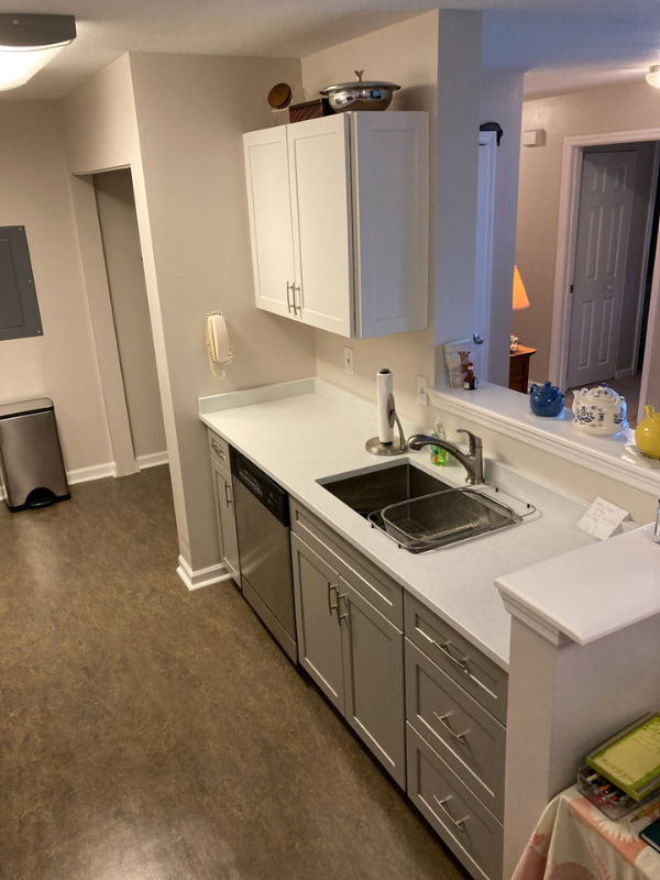 Shaker galley kitchen with white wall cabinets, gray base cabinets, and white quartz countertops