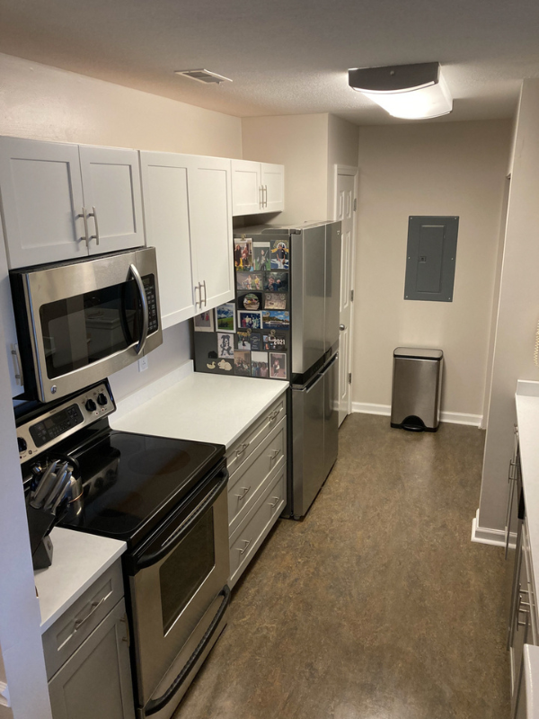 Shaker galley kitchen with white wall cabinets, gray base cabinets, and white quartz countertops