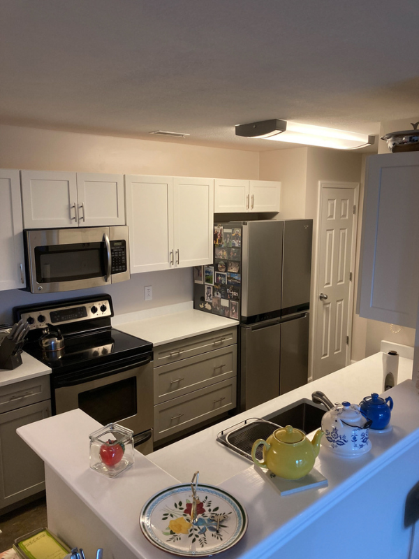 Shaker galley kitchen with white wall cabinets, gray base cabinets, and white quartz countertops