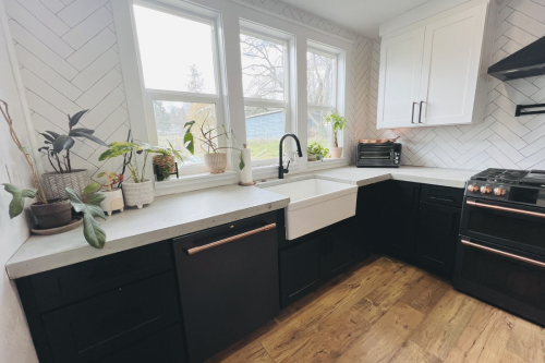 L-shaped kitchen design with black shaker base cabinets and white shaker upper cabinets and black cabinet handles