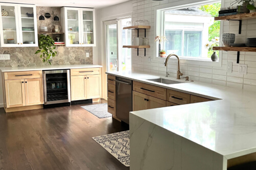 Light natural maple cabinet kitchen with white glass wall cabinets and black cabinet hardware in boho-style design 