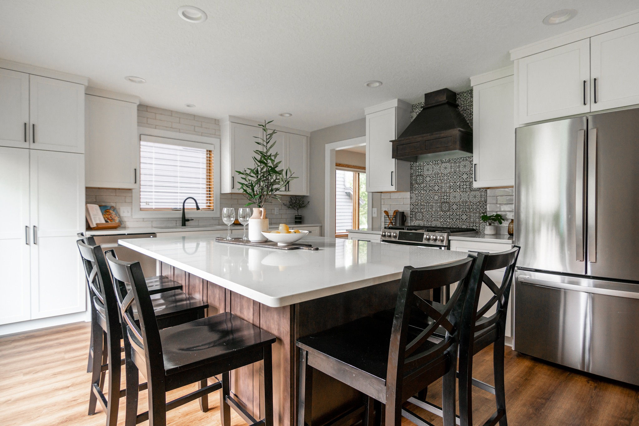 CliqStudios project: White shaker kitchen cabinetry with dark wood stained island and wood kitchen hood