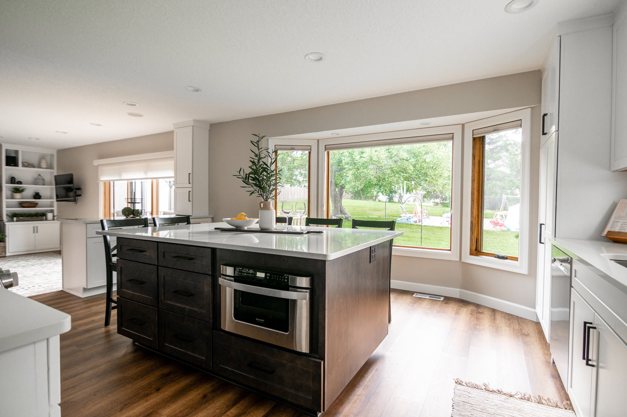 CliqStudios project: White shaker kitchen cabinetry with dark wood stained island