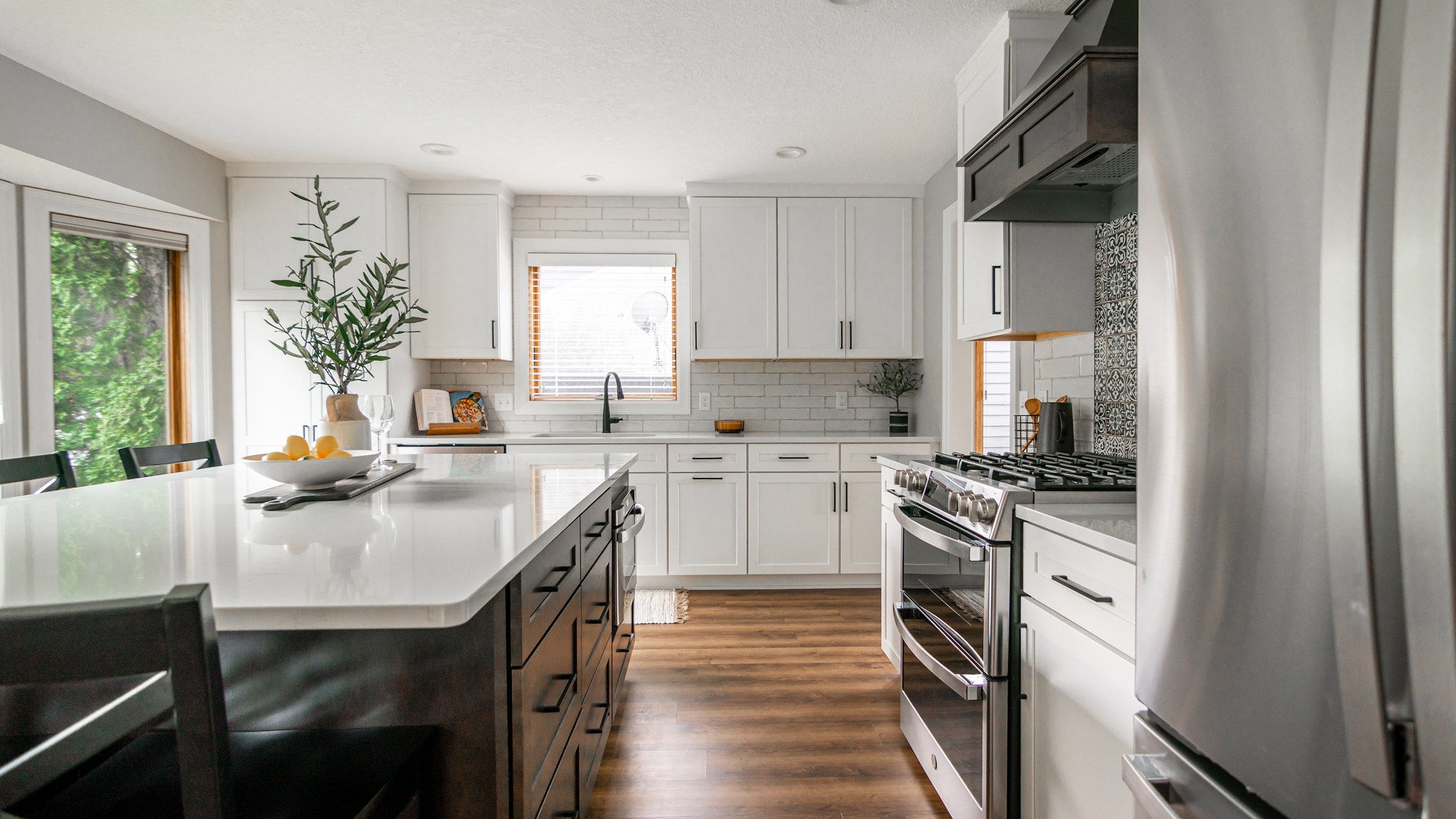 CliqStudios project: White shaker kitchen cabinetry with dark wood stained island and wood kitchen hood