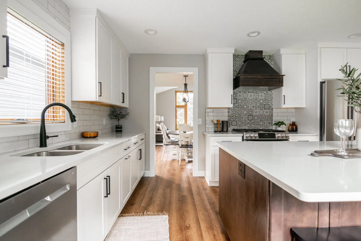 White shaker kitchen design with black cabinet handles and dark brown wood island