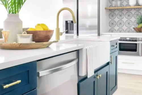 White shaker kitchen design with ocean blue shaker island cabinets, gold hardware and a white porcelain farm sink